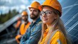 © huynh - Electrical engineers and business professionals discuss solar panel installation on a building, emphasizing alternative energy solutions.