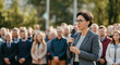 © IllustrationAlchemy - Woman doing a speech outdoor in front of a crowd.