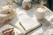 © Benjaporn - Flat-lay shot of a clean desk with open journal pen and cup of coffee with light steam in soft morning sunlight