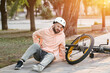© Pixel-Shot - Young man injured after falling off his bike in park
