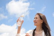 © photo pocket - 青空の下で水分補給をするシニア女性