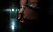 © Photo Builder - A gripping close-up shot of a prisoner’s  hands in heavy steel handcuffs