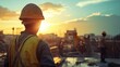 © logitech - Construction worker in hard hat and vest looking at sunset with a cityscape in the background.
