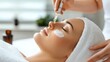 © chusnul - A woman receiving a facial treatment with a serum application in a spa setting.