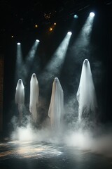 Poster - Four figures in white sheets standing on a stage with spotlights shining on them.