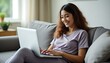 © AmberLand - Content Woman in Loungewear Working on Couch with Laptop