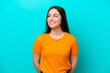 © luismolinero - Young caucasian woman isolated on blue background looking to the side and smiling