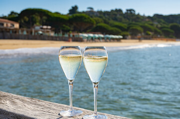 Summer time in Provence, two glasses of cold champagne cremant sparkling wine on famous Pampelonne sandy beach near Saint-Tropez in sunny day, Var department, France, beach club party