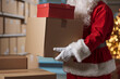 © StockPhotoPro - Santa Claus holding delivery boxes in the warehouse