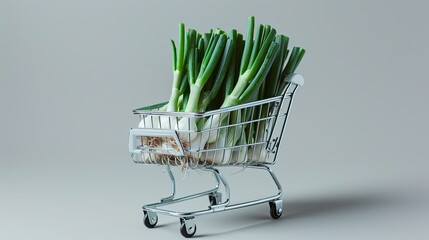 A small shopping cart filled with fresh green onions on a gray background.