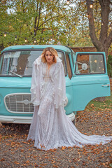 American blonde Woman in long white lace Boho dress with sleeves and fringe, fashionable outfit concept