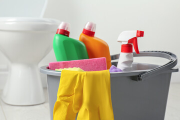 Poster - Bucket with different toilet cleaners in bathroom, closeup