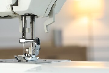 Wall Mural - Sewing machine on blurred background, macro view. Space for text