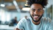 © Shutter2U - Smiling young African American man working in office.