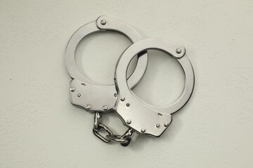 Classic chain handcuffs on white table, top view