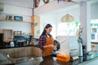© Odua Images - Indonesian waitress making coffee using a coffee maker in a coffee shop kitchen