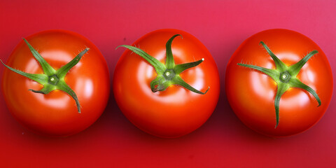 Poster - Three ripe red tomatoes sitting on a red background