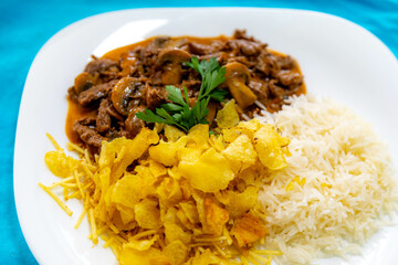 Traditional filet mignon stroganoff with mushrooms, French fries and rice