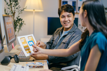 Poster - Two asian ui/ux designers happily discuss a mobile app wireframe in their office, brainstorming and planning together
