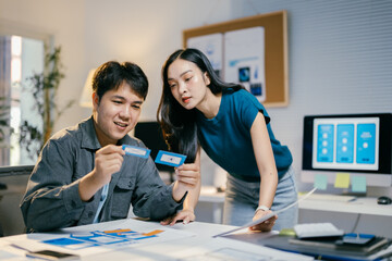 Poster - Two asian ui/ux designers collaborate on a mobile app layout, showcasing teamwork and creativity in an office setting