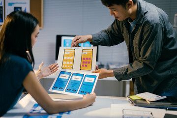 Poster - Two designers deeply engrossed in conversation about mobile app templates, analyzing user experience and interface elements in a modern office space