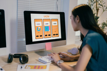 Poster - Focused asian woman designing user experience for mobile app in modern office, showcasing digital skills