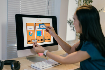 Poster - Young web designer is working on a user interface, arranging different elements of a mobile app on her computer screen