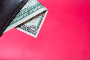 One Dollar Bill in Leather Wallet on Red Background