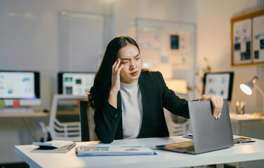 Aufkleber - stressed businesswoman closes laptop after long day at dark office. surround by paperwork, she shows