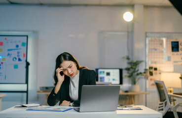 Aufkleber - stressed asian businesswoman is feeling tired and having a headache while using laptop and working w