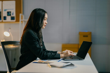 Poster - Focused young asian businesswoman working late on laptop in cluttered office, showcasing professional skills and determination for success