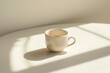 © Urszula - Single coffee cup on plain white table with soft lighting