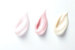 © Nataliia - Cream texture smears in light pink, white, and beige colors on a white background, representing skincare or cosmetic products