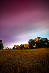 Aurora polar light in the night city , road with night polar sky . Red colors in the sky . Aurora landscape . Long exposure , small town with polar sky . Aurora in Ukraine . Rare nature effect, cloud 