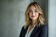 © Imagentive - Blonde Woman in White Shirt and Blazer Against Grey Wall
