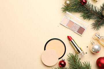 Canvas Print - Flat lay composition with makeup products and Christmas decor on beige background. Space for text