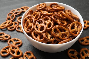 Wall Mural - Delicious pretzel crackers on black table, closeup