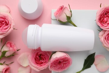 Wall Mural - Roll-on deodorant and beautiful rose flowers on pink background, flat lay