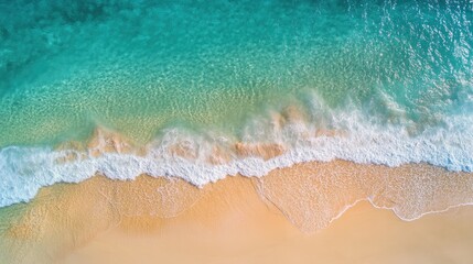  High-altitude view of a crystal-clear sea under the sun, with gentle waves and a golden sandy beach visible