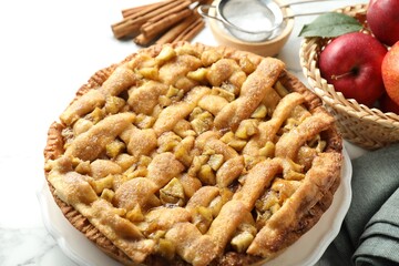 Homemade apple pie and ingredients on white marble table