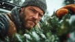 © JoxyAimages - An outdoorsy man wearing warm winter attire meticulously arranges the branches of a Christmas tree amid a snowy landscape, signifying dedication and festivity.