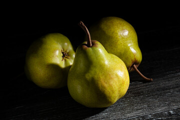 Poster - pear on black wood background