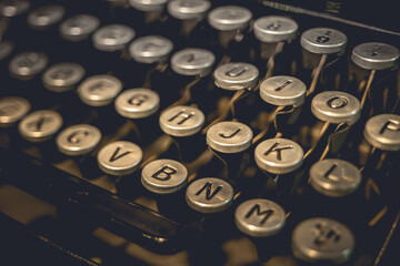 A close-up of the keys on an old typewriter, showing the letters G, H, J, K, L, V, B, N, M, and O