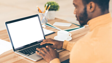 Aufkleber - Mock Up Template. Rear view of black man working on laptop with blank screen, typing on keyboard, copyspace