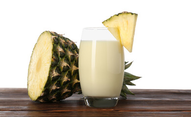 Wall Mural - Tasty pineapple smoothie in glass and slices of fruit on wooden table against white background