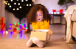 © Prostock-studio - My wish. Shocked happy african american little girl enjoying Christmas gift near Xmas tree, free space