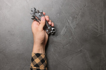 Poster - Auto mechanic with wrenches at grey textured table, closeup. Space for text