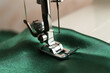 © New Africa - Sewing machine with green fabric on light background, closeup