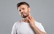 © Prostock-studio - Middle aged bearded man scratching highlighted with red neck on grey studio background, copy space. Annoyed man suffering from itch, having rash on his neck. Allergic reaction, eczema concept