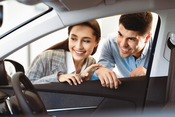 New Transport. Happy Husband And Wife Looking At New Auto Together, View From The Inside Of The Car. Copy Space